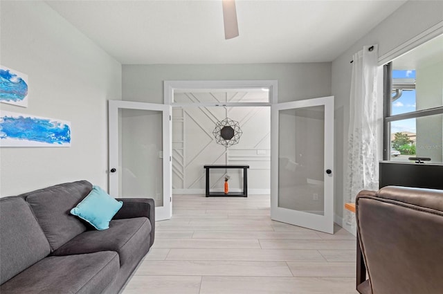 living room featuring ceiling fan, french doors, and light hardwood / wood-style flooring