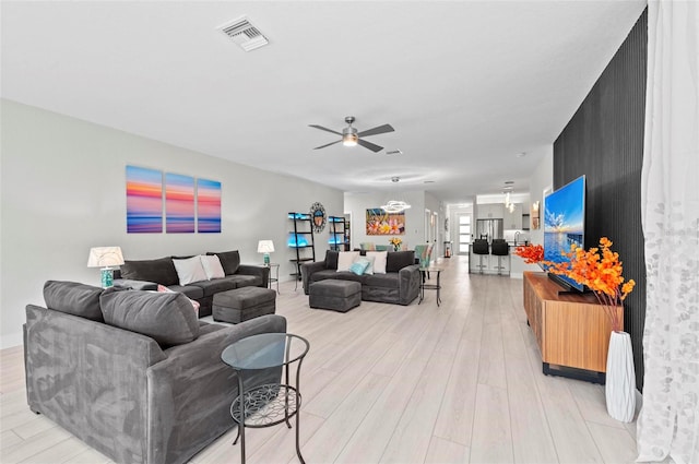 living room with light hardwood / wood-style floors and ceiling fan