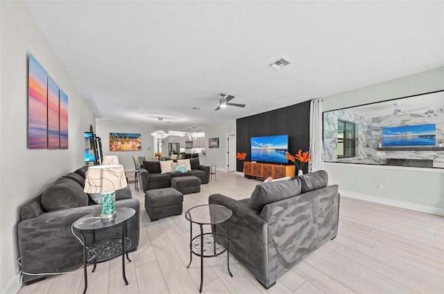 living room featuring ceiling fan and light wood-type flooring