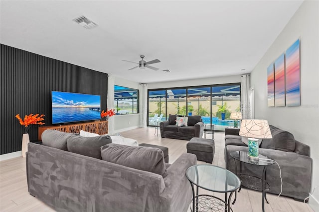 living room with light hardwood / wood-style flooring and ceiling fan