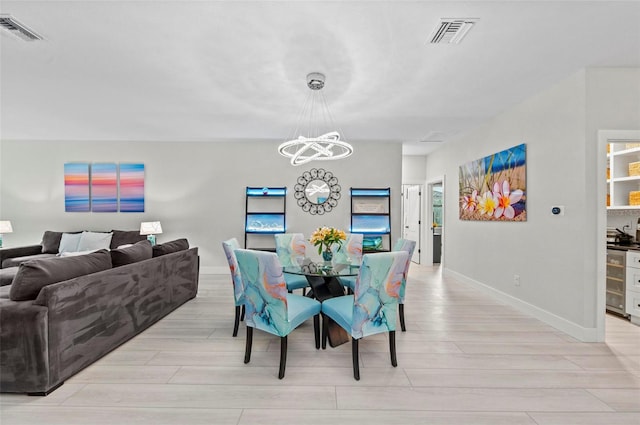 dining space featuring a notable chandelier, light hardwood / wood-style floors, and wine cooler