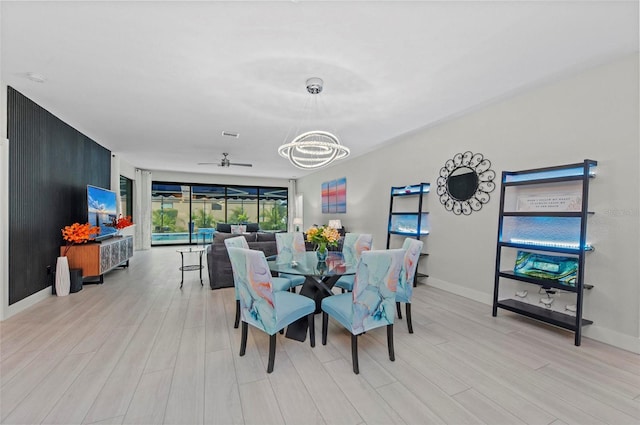 dining room featuring ceiling fan with notable chandelier and light wood-type flooring