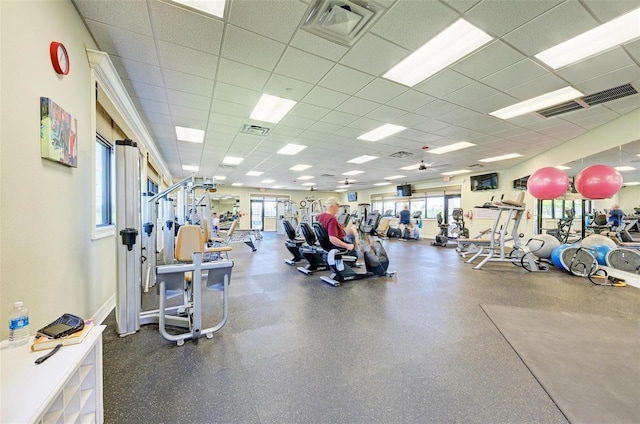 workout area featuring a paneled ceiling and a healthy amount of sunlight