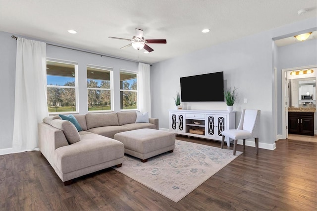 living room with dark wood-type flooring and ceiling fan