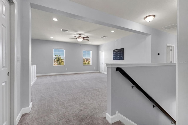 hallway featuring light colored carpet