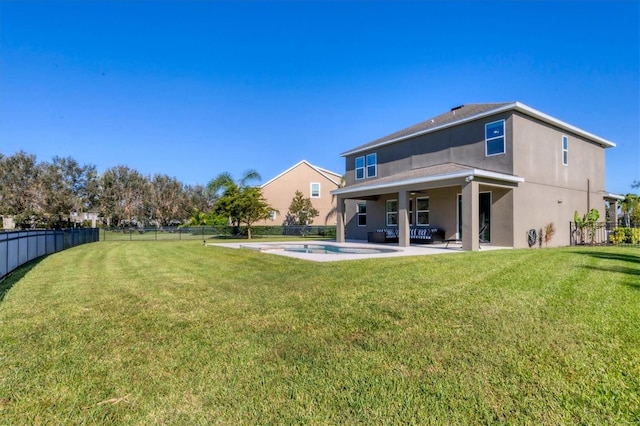 back of house with a fenced in pool, a patio area, and a yard