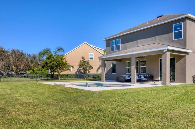 back of house featuring ceiling fan, a patio area, a fenced in pool, and a lawn