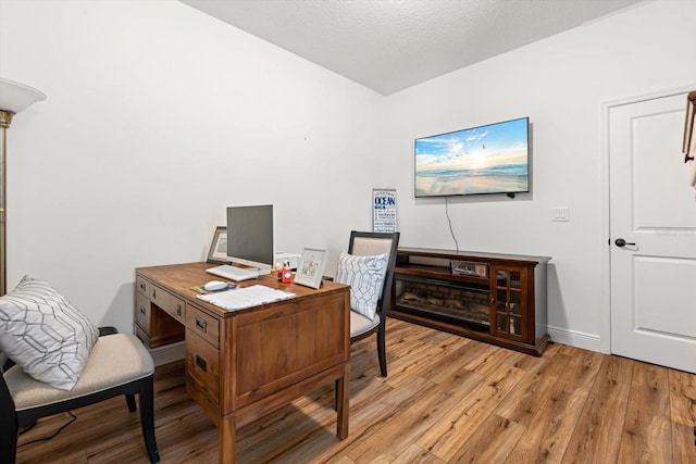 office with a textured ceiling and light hardwood / wood-style flooring