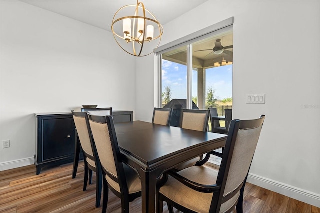 dining space with wood-type flooring and ceiling fan with notable chandelier