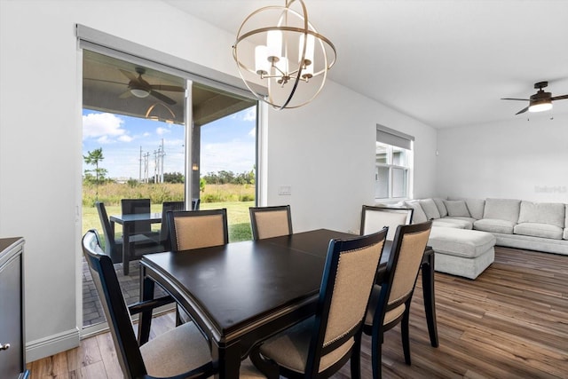 dining room with wood-type flooring and ceiling fan with notable chandelier