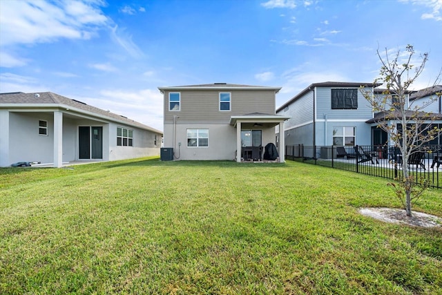 rear view of house with a lawn and central AC unit