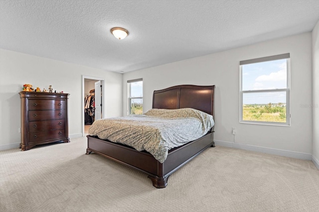 carpeted bedroom with a spacious closet, a closet, and a textured ceiling