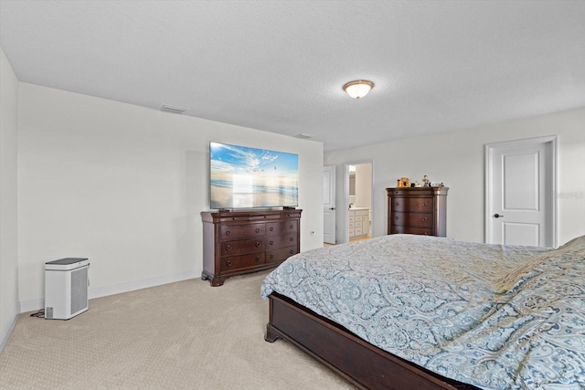 carpeted bedroom with a textured ceiling and ensuite bath