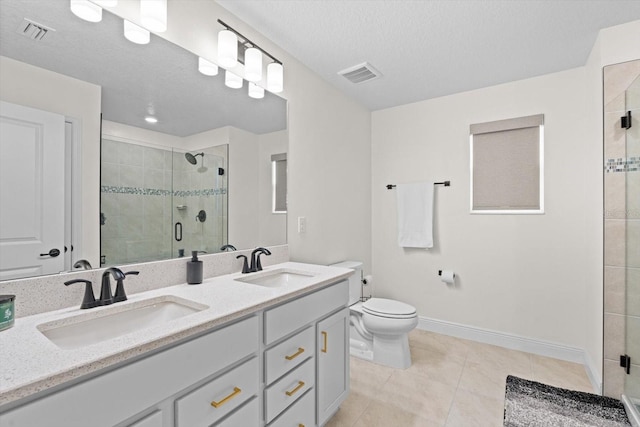 bathroom featuring a textured ceiling, walk in shower, toilet, vanity, and tile patterned floors