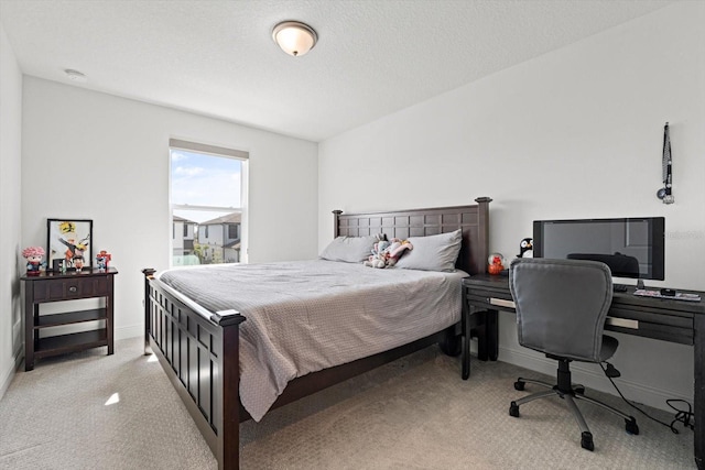 bedroom featuring a textured ceiling and light colored carpet