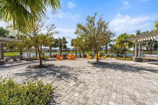 view of home's community with a patio area, a water view, and a pergola