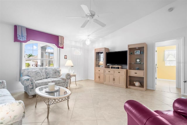 living room featuring ceiling fan, a wealth of natural light, light tile patterned floors, and vaulted ceiling