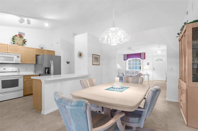 tiled dining room with ceiling fan with notable chandelier