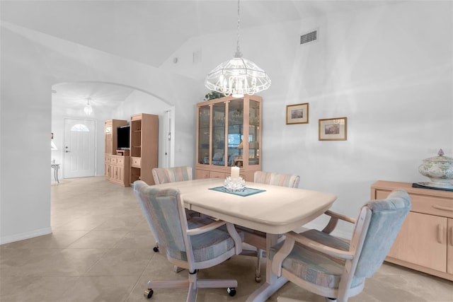 tiled dining space featuring lofted ceiling and an inviting chandelier