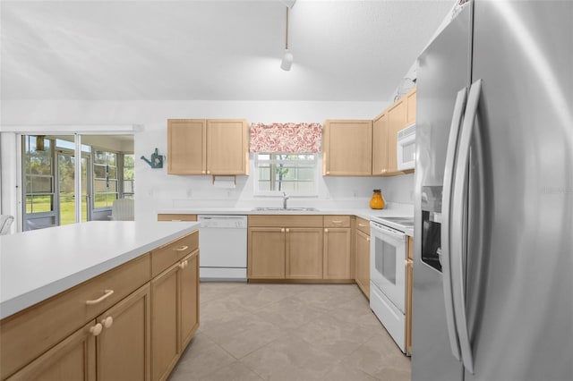 kitchen with light brown cabinets, sink, light tile patterned floors, and white appliances