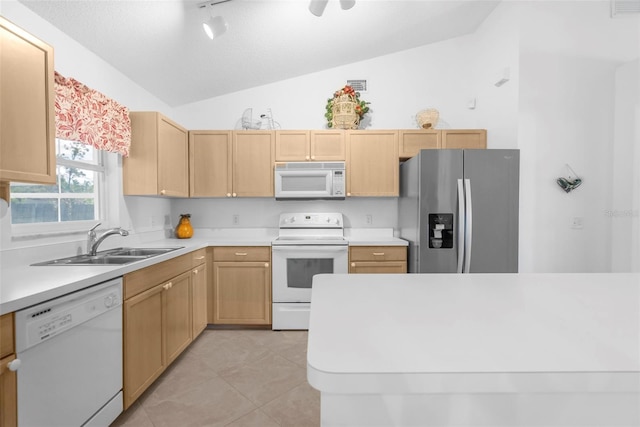 kitchen with sink, vaulted ceiling, white appliances, and light brown cabinets