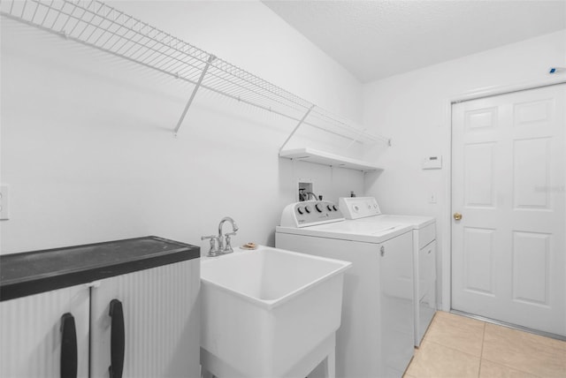 laundry area featuring light tile patterned flooring, sink, and washing machine and clothes dryer