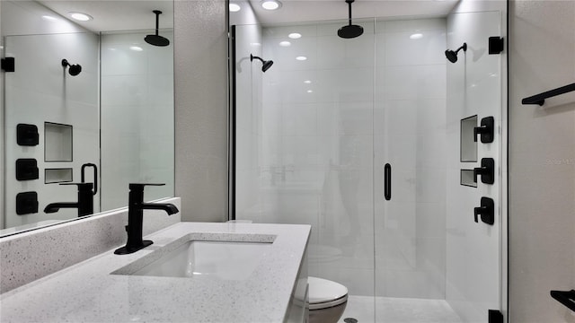 bathroom with vanity, toilet, and a shower with shower door