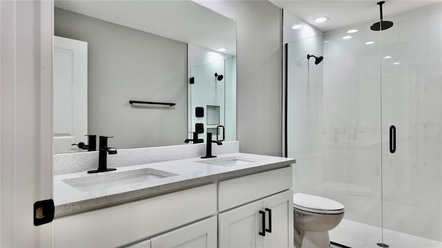 bathroom featuring vanity, toilet, and a shower with shower door