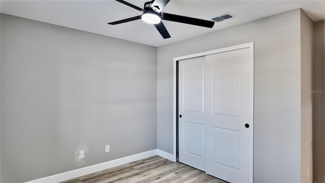 unfurnished bedroom featuring light hardwood / wood-style flooring, a closet, and ceiling fan