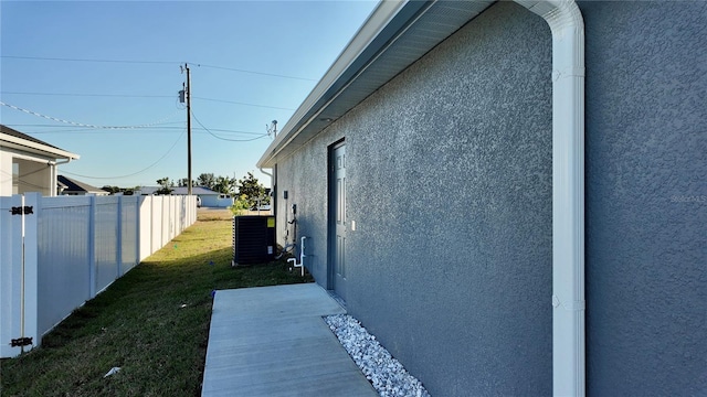 view of home's exterior with a yard and central AC unit