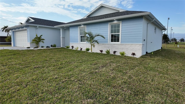 ranch-style house featuring a front yard and a garage