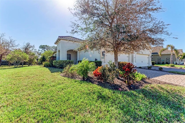 1269 Backspin Dr, Englewood, FL 34223 - view of property exterior featuring stucco siding, driveway, a yard, and an attached garage