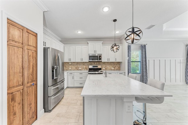 1269 Backspin Dr, Englewood, FL 34223 - kitchen featuring a kitchen breakfast bar, decorative backsplash, crown molding, white cabinets, and appliances with stainless steel finishes