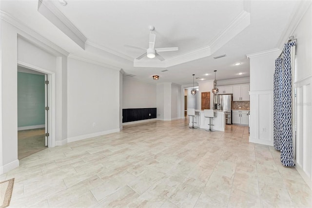 1269 Backspin Dr, Englewood, FL 34223 - unfurnished living room featuring visible vents, a raised ceiling, ceiling fan, baseboards, and ornamental molding
