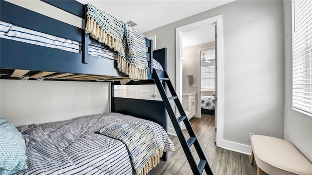 bedroom with connected bathroom and wood-type flooring