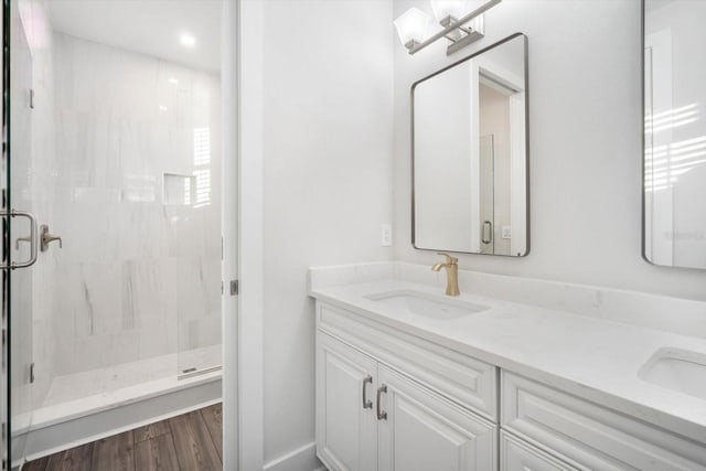 bathroom with a shower with door, vanity, and hardwood / wood-style flooring