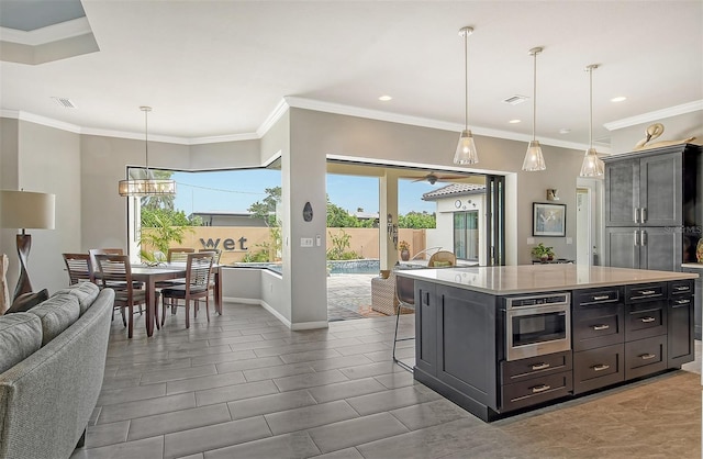 kitchen featuring crown molding, a breakfast bar, hanging light fixtures, and a kitchen island