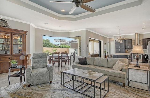 living room featuring ceiling fan with notable chandelier and ornamental molding