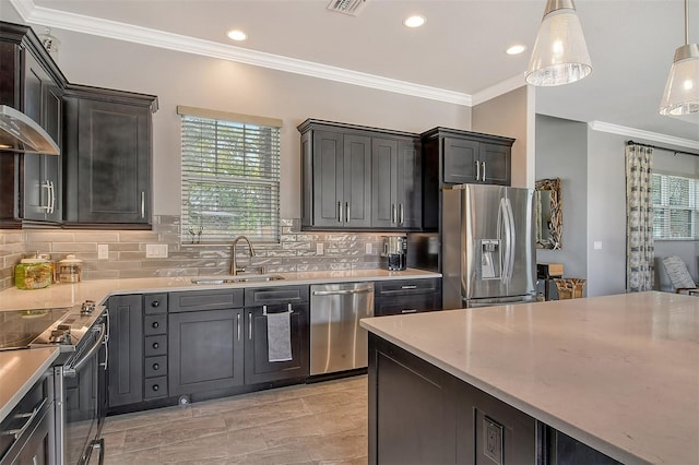 kitchen featuring sink, crown molding, hanging light fixtures, appliances with stainless steel finishes, and backsplash