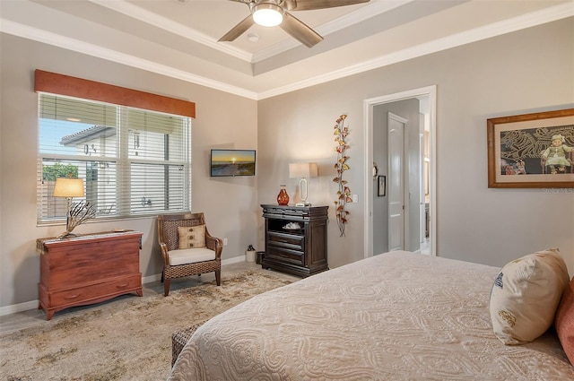 bedroom with crown molding, a tray ceiling, and light carpet