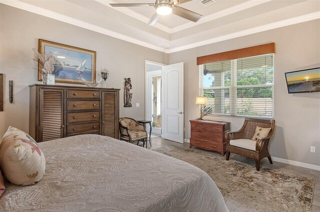 bedroom with crown molding, ceiling fan, and a tray ceiling