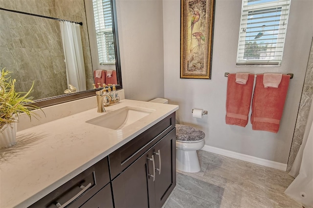 bathroom featuring vanity, plenty of natural light, and toilet