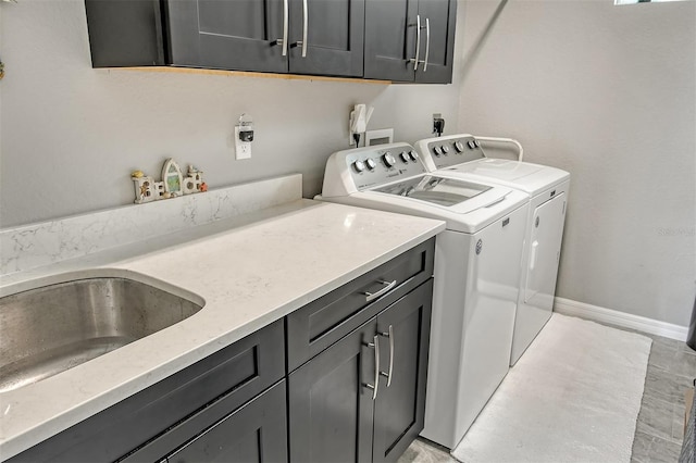 clothes washing area featuring washer and dryer and cabinets