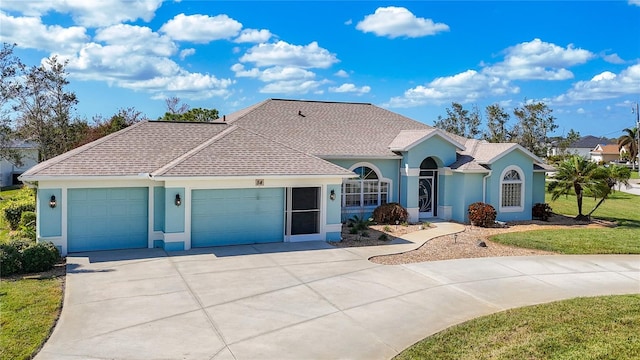 ranch-style house featuring concrete driveway, stucco siding, a front yard, and a garage