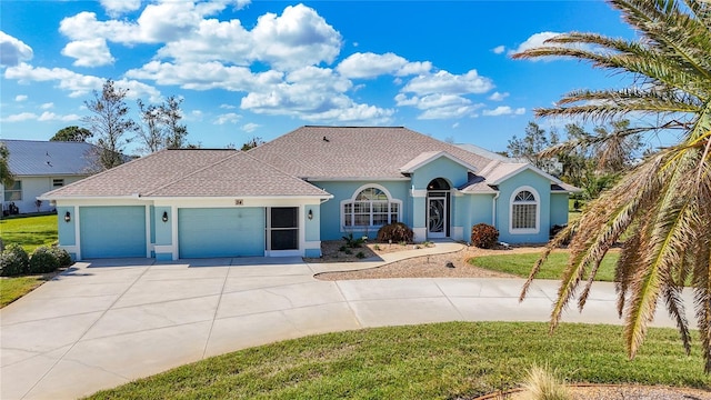 view of front facade with an attached garage, concrete driveway, stucco siding, and a front yard