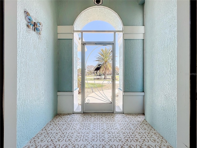 doorway to outside featuring a textured wall