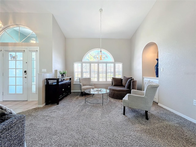 living area featuring high vaulted ceiling, baseboards, carpet flooring, and arched walkways