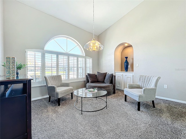 living area featuring an inviting chandelier, carpet floors, and lofted ceiling