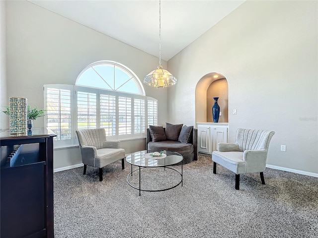 living area featuring baseboards, carpet flooring, and high vaulted ceiling