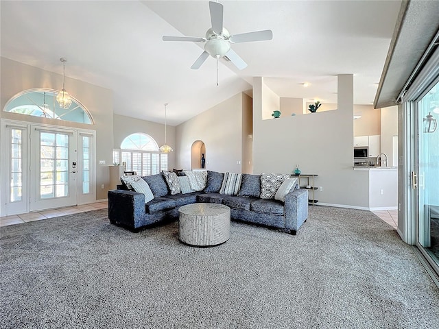 living room featuring carpet floors, a ceiling fan, high vaulted ceiling, and baseboards